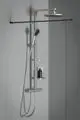 Duschsystem von Ideal Standard mit einer Kopfbrause und Handbrause, zwei Ablagen und regulierbarer Temperatur. Montiert an einer hellen Wand.